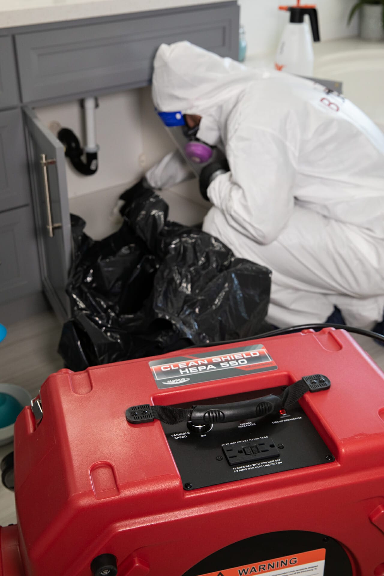 Bio-One's mold remediation technician disposing of mold waste in double bag